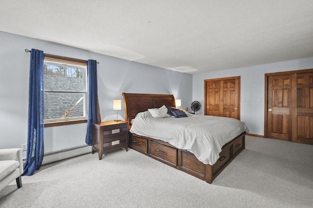 bedroom featuring a textured ceiling, light colored carpet, and baseboard heating