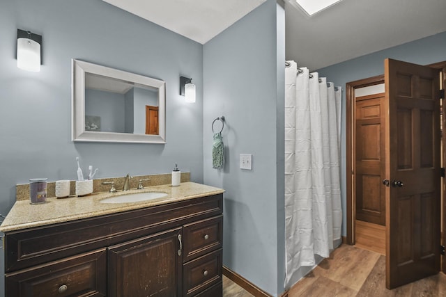 bathroom featuring a shower with shower curtain, hardwood / wood-style floors, and vanity