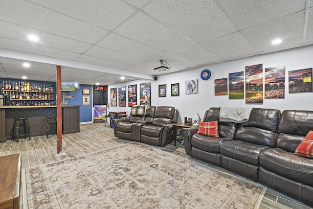 living room with a drop ceiling and bar