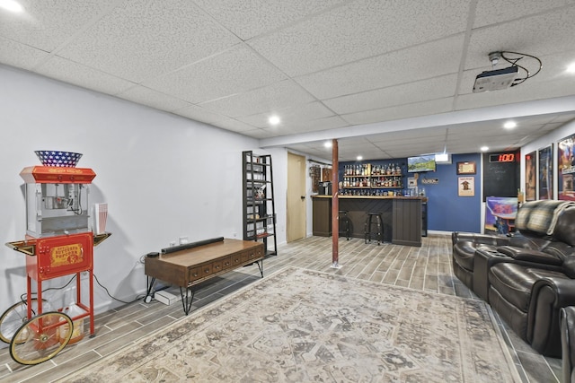 living room featuring indoor bar and a paneled ceiling