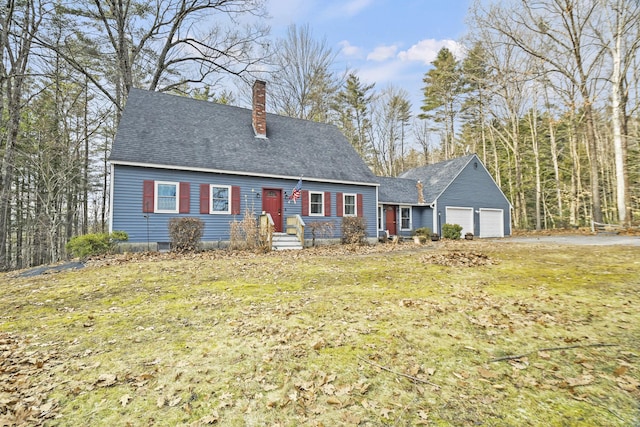 cape cod house featuring a front lawn and a garage