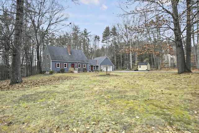 view of front of house with a storage unit and a front lawn