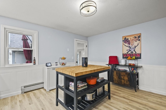 dining space with light hardwood / wood-style flooring and a baseboard heating unit