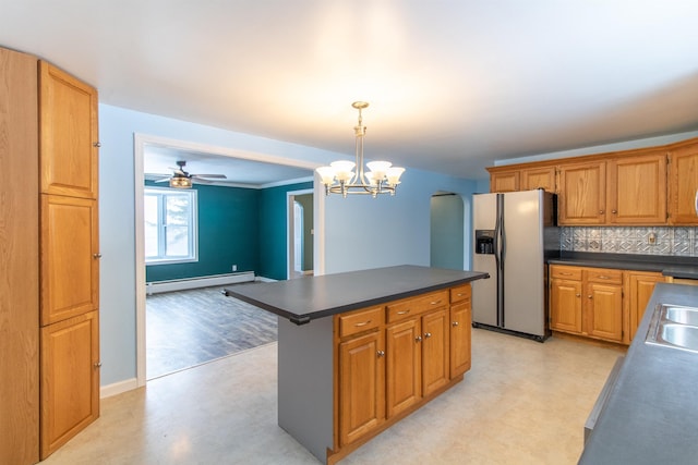 kitchen with pendant lighting, ceiling fan with notable chandelier, decorative backsplash, baseboard heating, and stainless steel fridge with ice dispenser