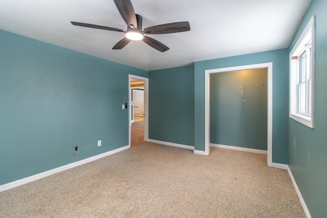 unfurnished bedroom featuring ceiling fan, light colored carpet, and a closet