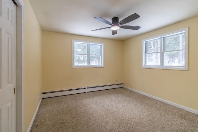 empty room with carpet, a wealth of natural light, ceiling fan, and a baseboard heating unit