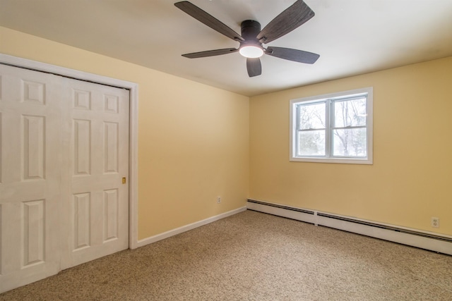 unfurnished bedroom with carpet, a closet, baseboard heating, and ceiling fan