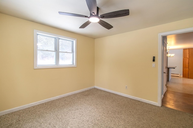 unfurnished room featuring carpet flooring, ceiling fan with notable chandelier, and a baseboard heating unit