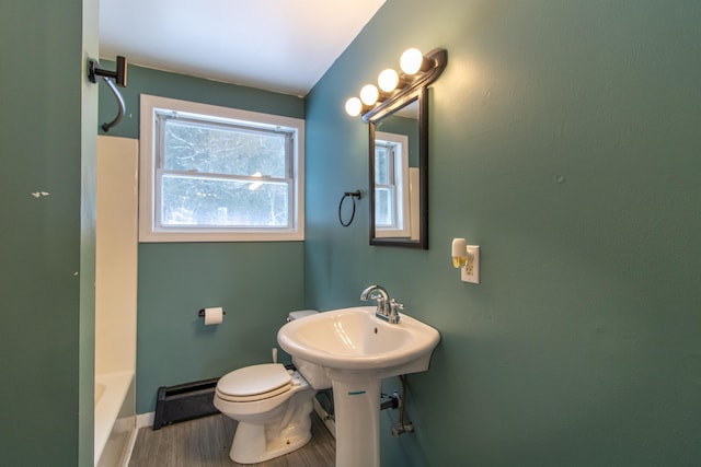 bathroom featuring a washtub, toilet, and wood-type flooring