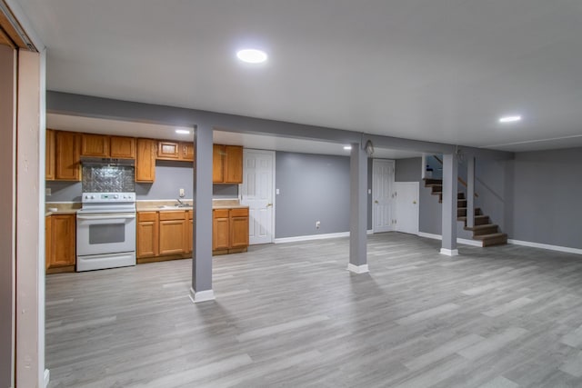 basement with light hardwood / wood-style flooring and sink