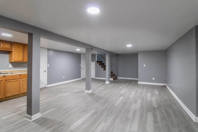 basement featuring light hardwood / wood-style floors and sink