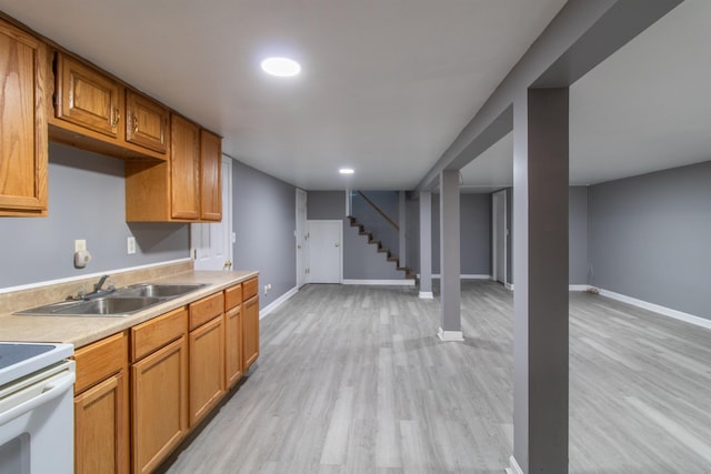 kitchen with light wood-type flooring, white electric stove, and sink