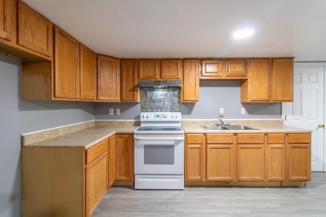 kitchen featuring white range with electric cooktop, sink, and light wood-type flooring