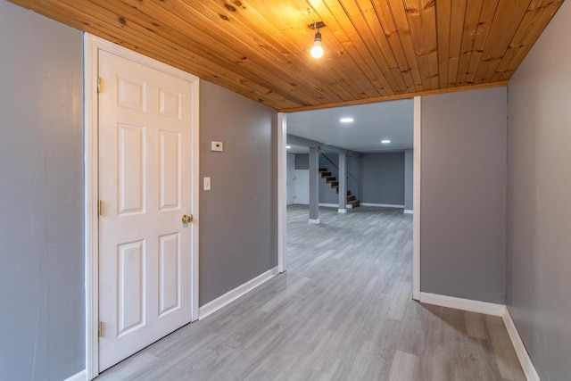 hallway with light hardwood / wood-style floors and wooden ceiling