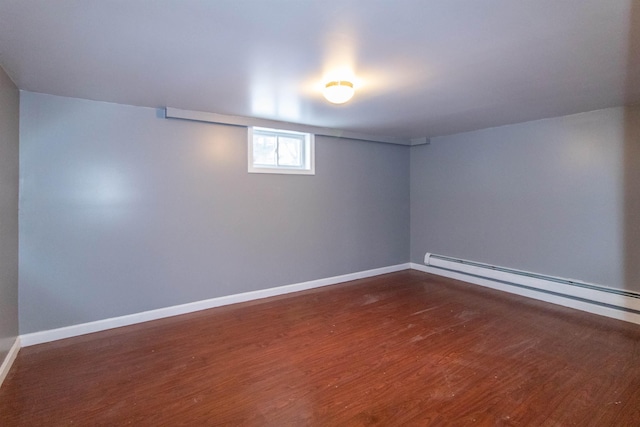 basement featuring dark hardwood / wood-style flooring and baseboard heating