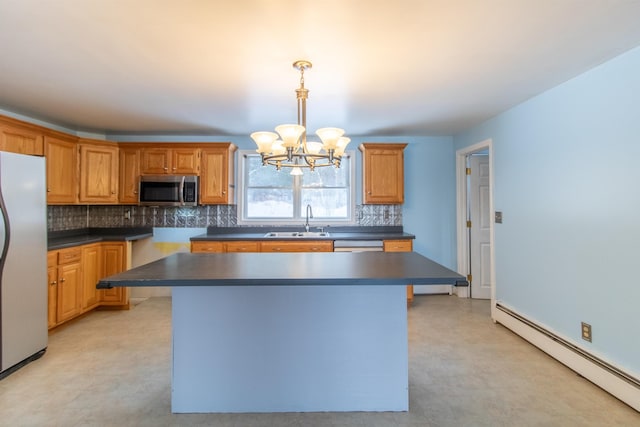 kitchen featuring sink, stainless steel appliances, baseboard heating, a notable chandelier, and a kitchen island