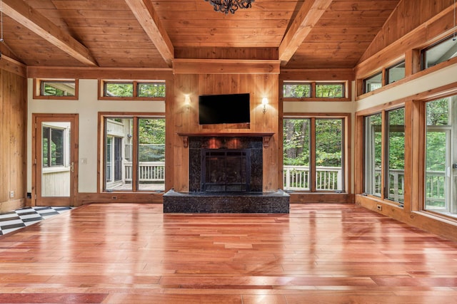 unfurnished living room with vaulted ceiling with beams, light hardwood / wood-style floors, wooden ceiling, and a fireplace