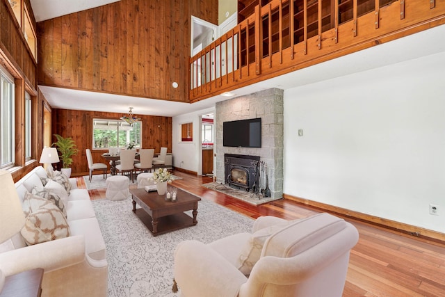 living room featuring wood walls, a towering ceiling, and wood-type flooring