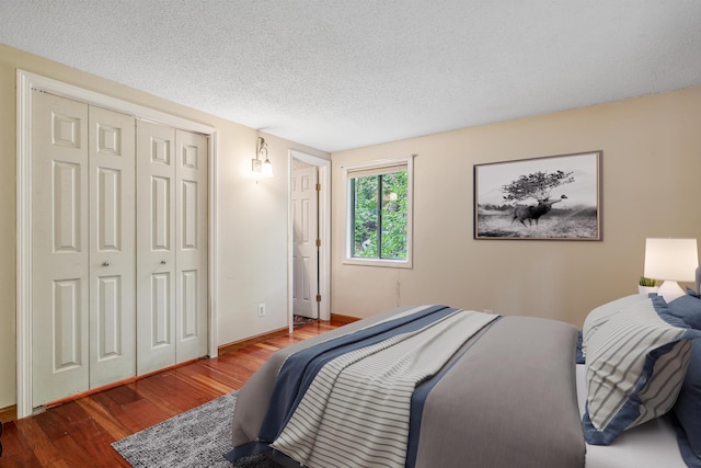 bedroom with wood-type flooring, a textured ceiling, and a closet