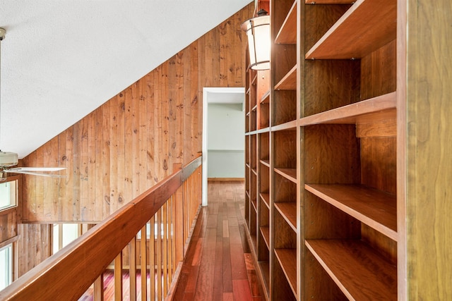 hall featuring wood-type flooring and wooden walls