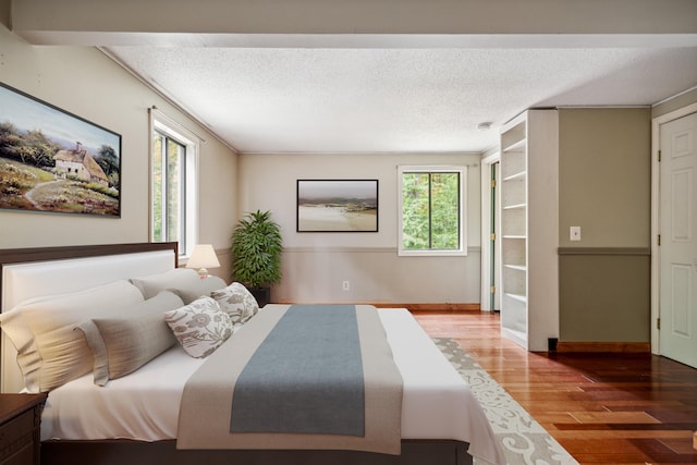 bedroom with hardwood / wood-style floors and a textured ceiling