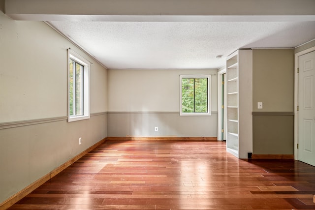 spare room with wood-type flooring and a textured ceiling