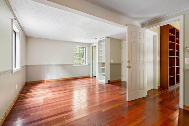 spare room featuring wood-type flooring and a textured ceiling