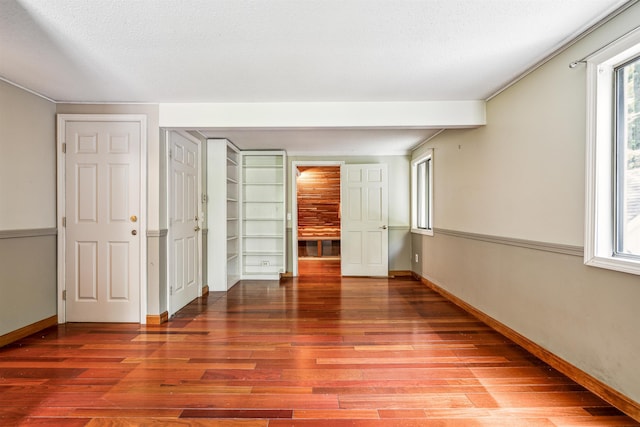 unfurnished room with wood-type flooring and a textured ceiling