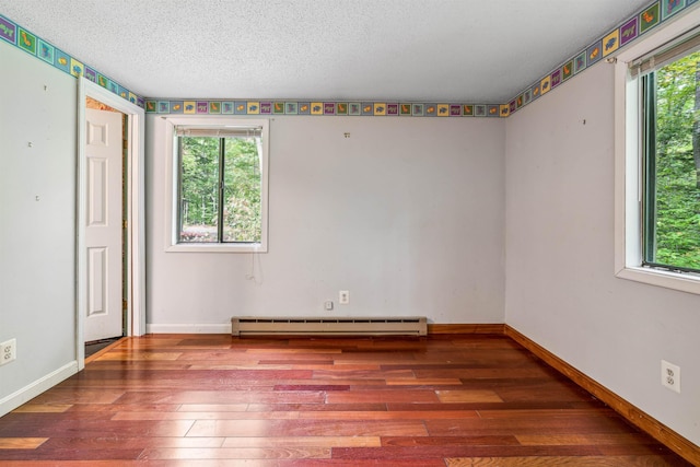 unfurnished room featuring hardwood / wood-style flooring, plenty of natural light, a textured ceiling, and a baseboard heating unit