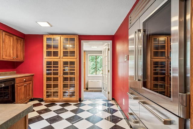 kitchen with high end refrigerator, a textured ceiling, wine cooler, and french doors