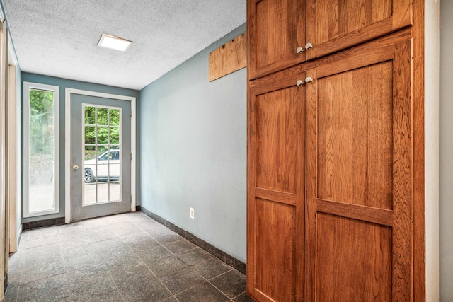 doorway to outside with a textured ceiling