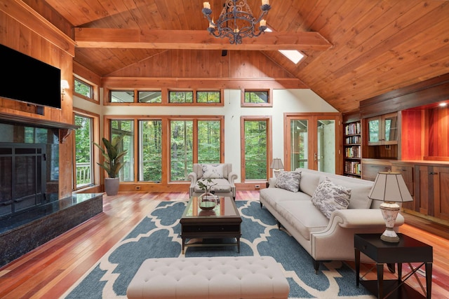 living room with high vaulted ceiling, beamed ceiling, wood-type flooring, and a notable chandelier