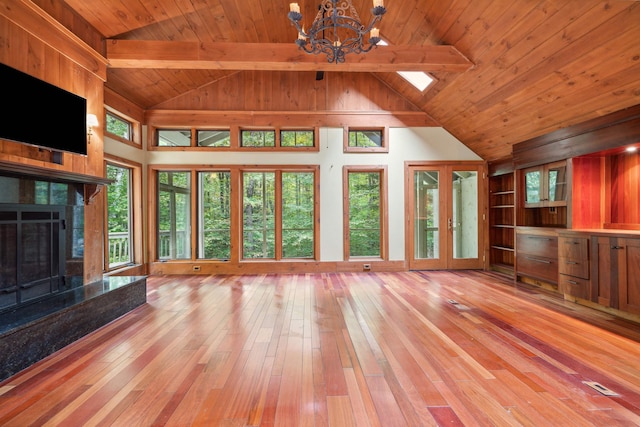 unfurnished living room with wooden ceiling, french doors, a fireplace, beamed ceiling, and light hardwood / wood-style floors