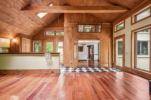 unfurnished living room with hardwood / wood-style flooring, wood ceiling, and wooden walls