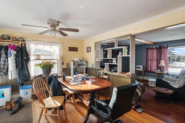 dining room with a textured ceiling, crown molding, ceiling fan, and wood finished floors