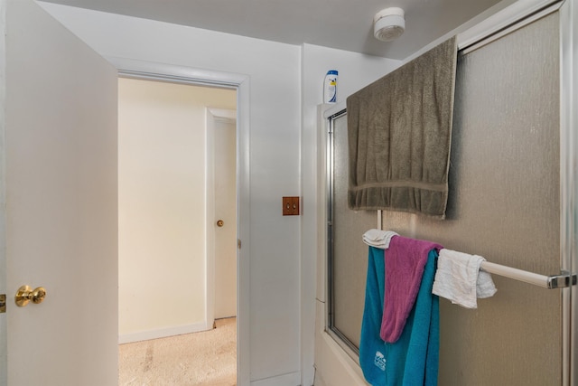 full bathroom with an enclosed shower and baseboards