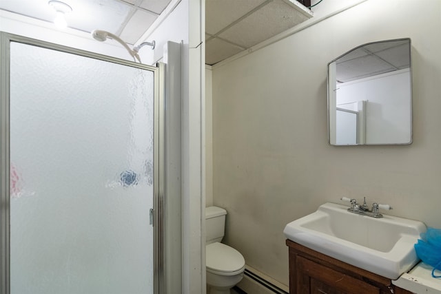 bathroom featuring toilet, a shower stall, a baseboard radiator, a paneled ceiling, and vanity