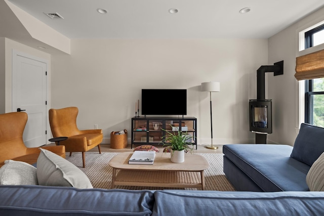 living room with hardwood / wood-style floors and a wood stove