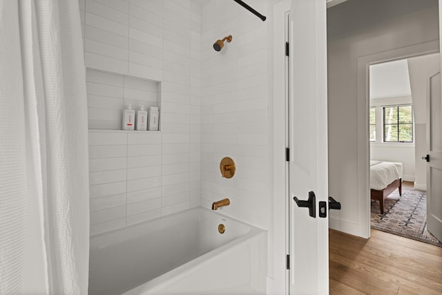 bathroom with wood-type flooring and shower / bath combo with shower curtain