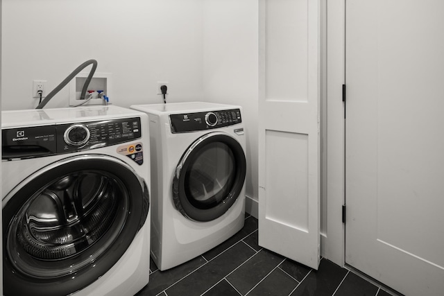 clothes washing area with dark tile patterned flooring and independent washer and dryer