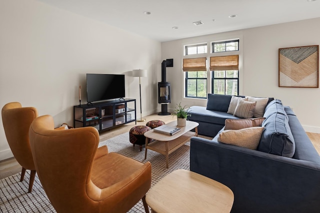 living room featuring light wood-type flooring and a wood stove