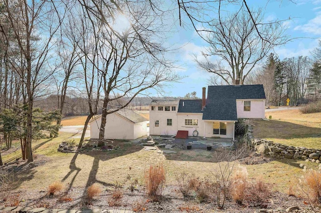 back of house featuring a lawn and a patio area