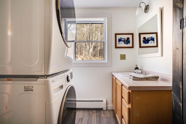 washroom with cabinets, dark hardwood / wood-style flooring, stacked washer and clothes dryer, and sink