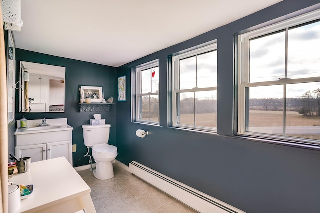 bathroom with vanity, toilet, and a baseboard heating unit