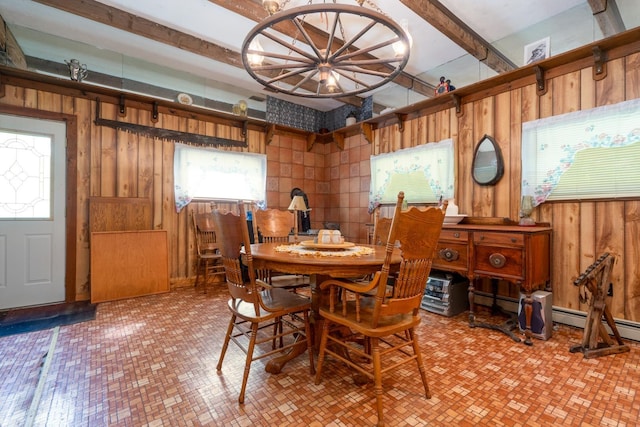 dining room with a baseboard heating unit and wood walls