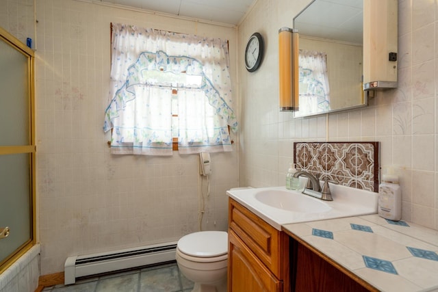 full bathroom featuring vanity, bath / shower combo with glass door, toilet, baseboard heating, and tile walls