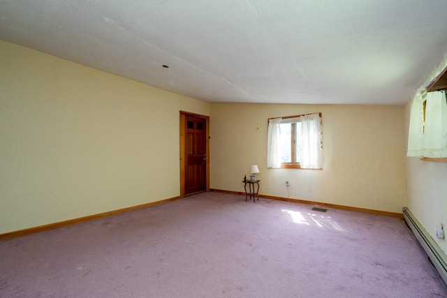 unfurnished room with baseboard heating, vaulted ceiling, light colored carpet, and a textured ceiling