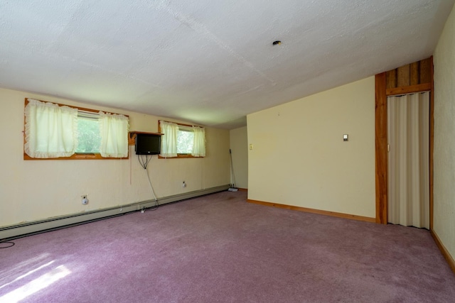 carpeted spare room with baseboard heating and a textured ceiling