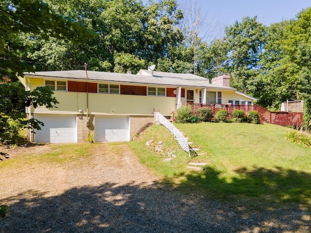 view of front facade with a front yard, a porch, and a garage