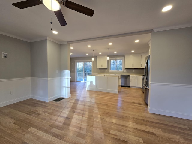 kitchen with a center island, white cabinets, hanging light fixtures, light hardwood / wood-style floors, and stainless steel appliances